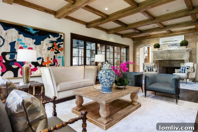 Cozy family room featuring wood-beamed ceilings and a stone fireplace, blending traditional and modern styles.