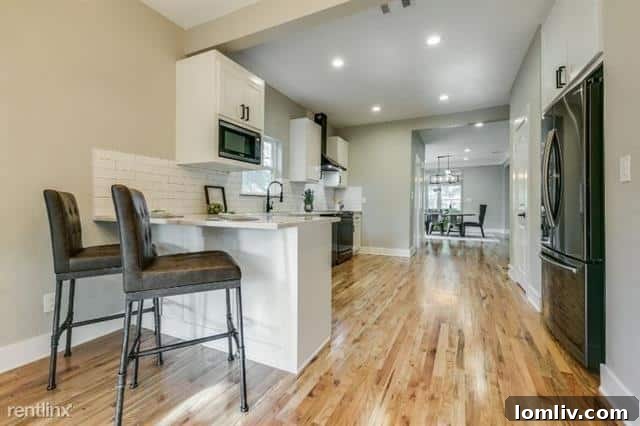 A well-appointed kitchen in the North Oak Cliff home, featuring black stainless steel appliances and subway tiles.