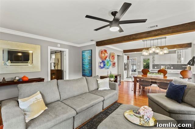 Modern chef's kitchen with marble countertops, white cabinetry, and brass hardware, open to the living area