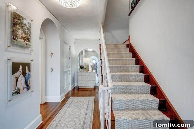 Berkley Place's Perfect Tudor: A Forest Park Masterpiece 3 Inviting Interior Entrance with Arched Openings and Hardwood Floors