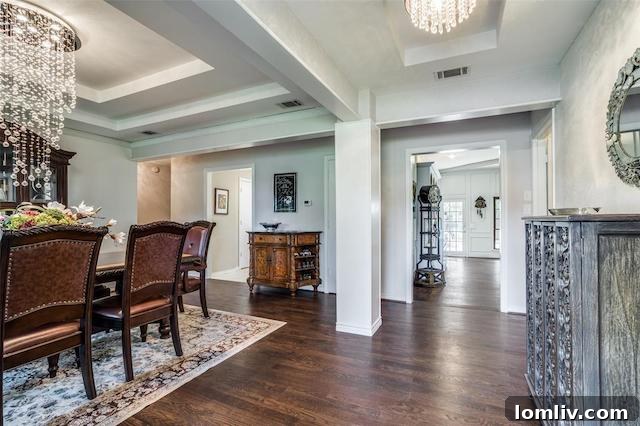 A bright and open living area with rich hardwood floors, exposed ceiling beams, and ample space for entertaining guests.