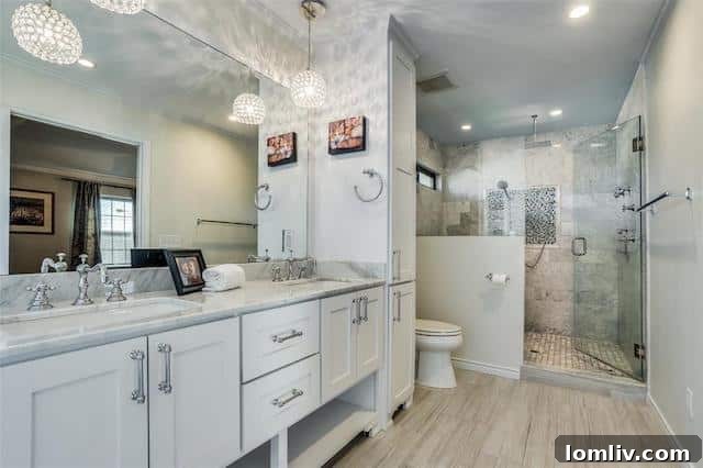 The beautifully renovated master bathroom, featuring dual vanities, modern fixtures, and a spacious walk-in shower.