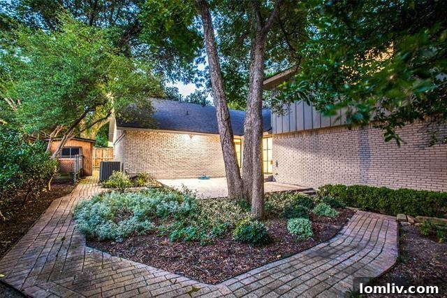 The tranquil and low-maintenance backyard of the Lake Highlands home, featuring mature trees providing shade and privacy.