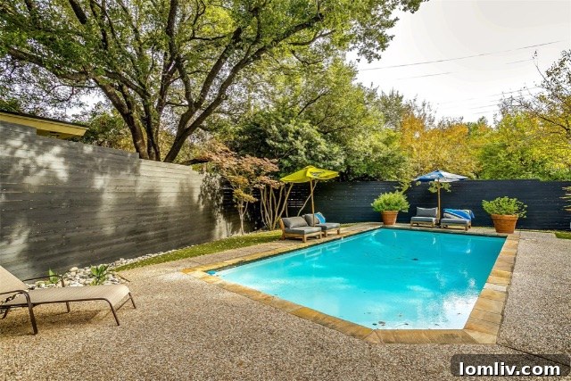 Midcentury Brilliance: A Home That Colors Your World with Joy 4 Serene swimming pool with pebbled deck and vibrant Japanese maples in a Dallas backyard