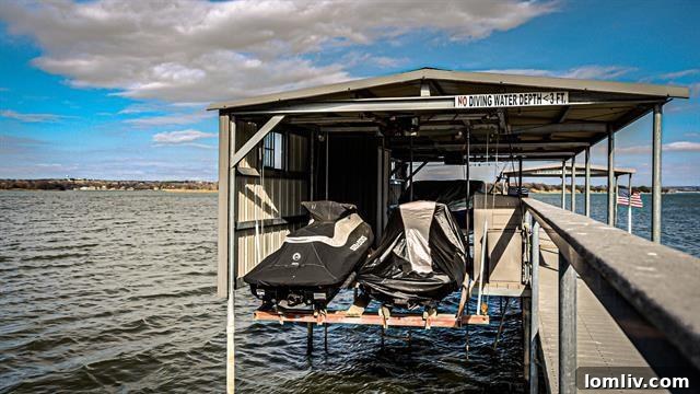 The private boat dock and sandy beach area at 9432 Heron Drive, perfect for water sports.