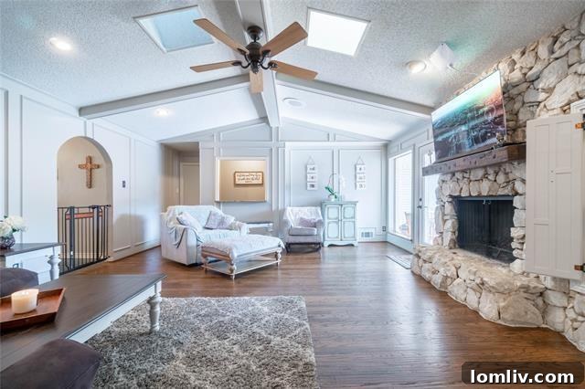 Lake Highlands Radiant Renewal 4 Bright and airy living room with vaulted beam ceilings and a stone fireplace in a Lake Highlands home.