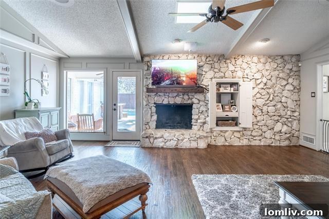 Lake Highlands Radiant Renewal 5 Living room with refinished wood floors, skylights, and detailed paneling, featuring a hidden wet bar.