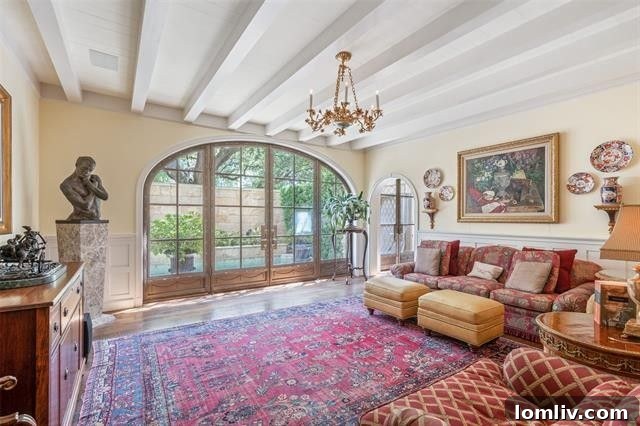 An inviting informal family room on the first level, featuring comfortable seating and a direct access point to the private marble lap pool