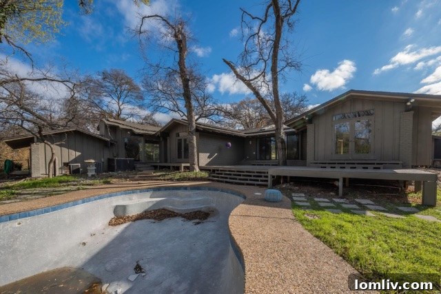 The backyard of the Mid-Century Modern home with a non-functioning pool