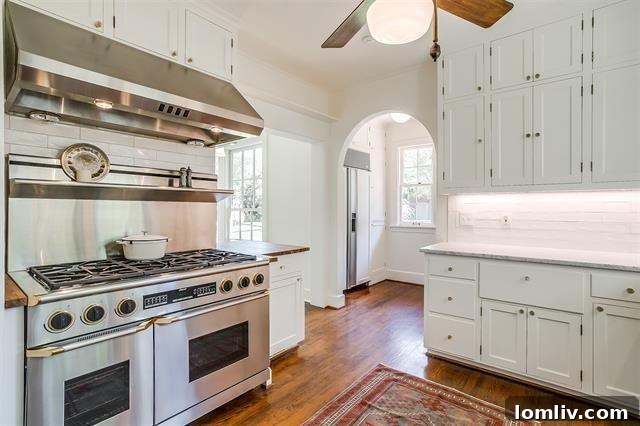 Well-appointed kitchen featuring marble countertops, a professional-grade gas range, and elegant cabinetry in the renovated Winton Terrace residence.