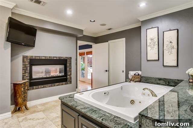 Luxurious primary bedroom with shared fireplace and garden views