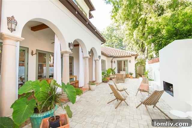 Mediterranean Masterpiece on Bunting Avenue 17 Chic walled back garden with covered arcade and outdoor fireplace