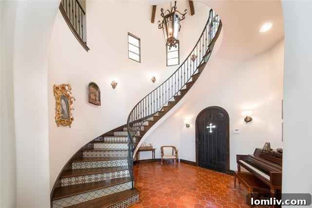 Mediterranean Masterpiece on Bunting Avenue 4 Inviting entry hall with cotto floors and custom wrought iron banister
