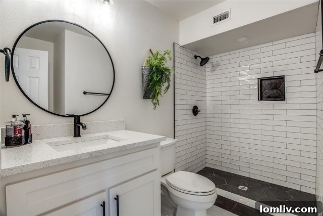 Luxurious modern bathroom with double vanity, walk-in shower, and contemporary fixtures post-renovation