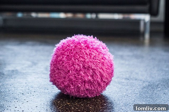 Cute Mocoro Robot Cleaning Ball rolling across a floor, collecting dust