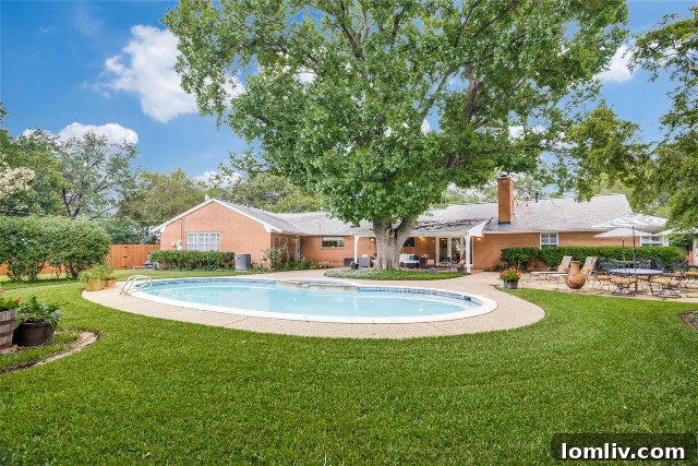 Inviting Backyard Oasis with Sparkling Pool, Green Lawn, and Sunbathing Areas