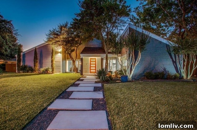 Modern contemporary home exterior with cool gray brick and vibrant orange door at 7015 Duffield Drive, Dallas