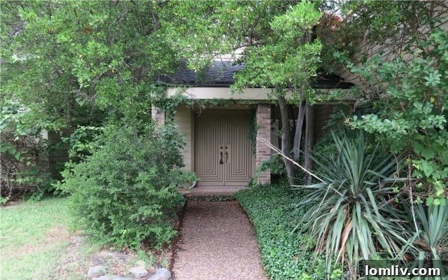 Before renovation: Overgrown and neglected exterior of 7015 Duffield Drive in 2017
