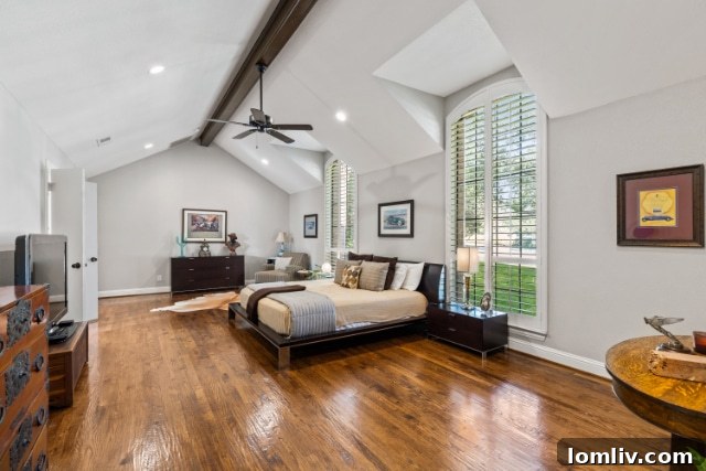 Luxurious primary bedroom with high ceilings and abundant natural light