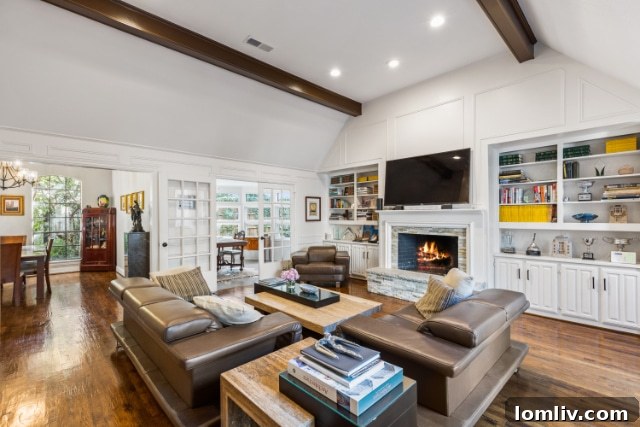 Formal living room with chic wood and stone fireplace in Dallas home