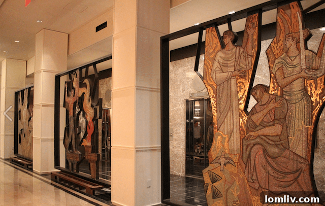 Team members carefully removing sections of the mosaic