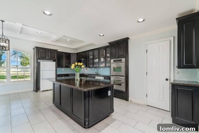 Bright and airy kitchen with white cabinetry, a large island, and dining area