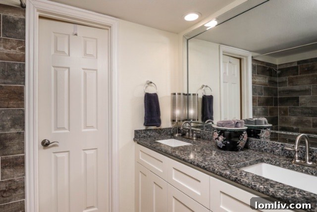 Primary bathroom with granite and updated tile in the geodesic dome home.