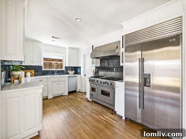 Spacious and modern chef's kitchen with a large waterfall island and high-end appliances.