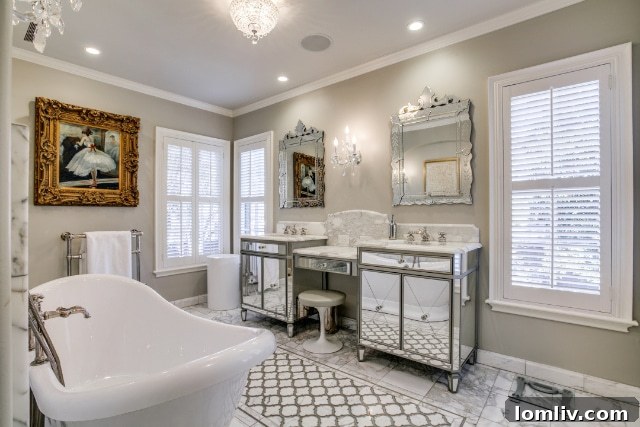 The opulent ensuite bath and dressing area in the principal suite, featuring marble, double vanities, a freestanding tub, and a walk-in shower.