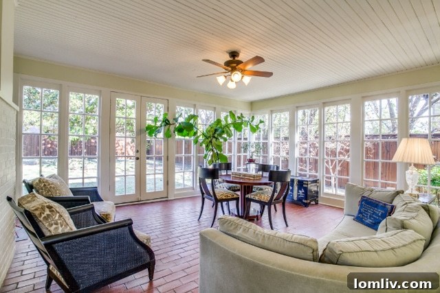 French doors opening into a sun-drenched, brick-floored garden room that offers expansive views of the private backyard.