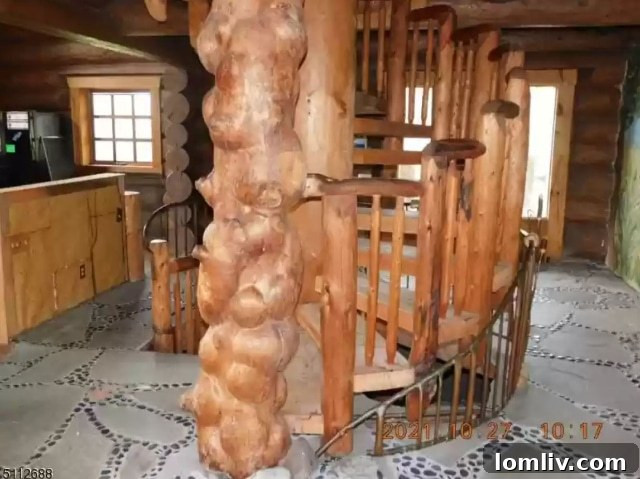 Hand-crafted spiral wooden staircase in the center of the cabin, extending downwards