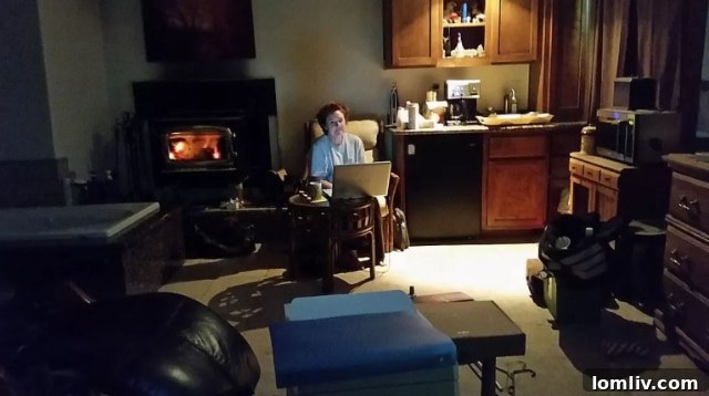 Dark home office with a woman working on computer