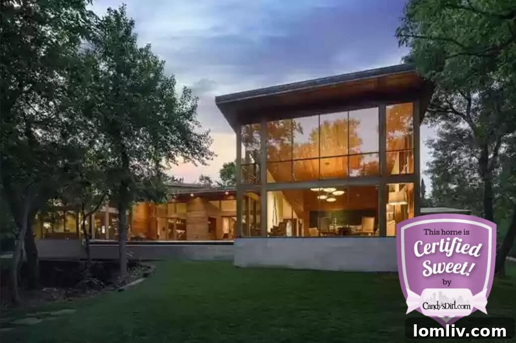 An aerial view of a stunning modern home with a lush green lawn and an infinity pool, reflecting the sky. Part of the 'Sweetest Homes in Dallas-Fort Worth' collection.