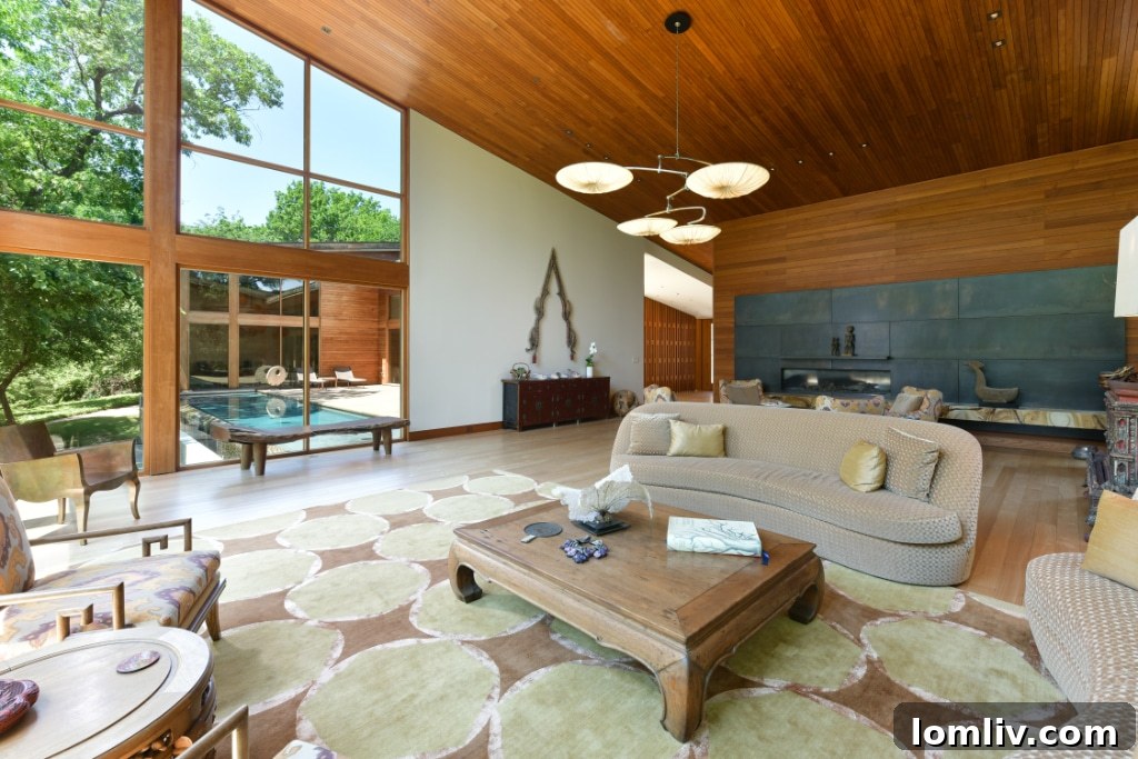 A closer view of the recycled hardwood floors and floor-to-ceiling windows, highlighting the seamless integration of natural light and materials.