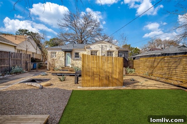 View of the gravel patio with agave plants and fence