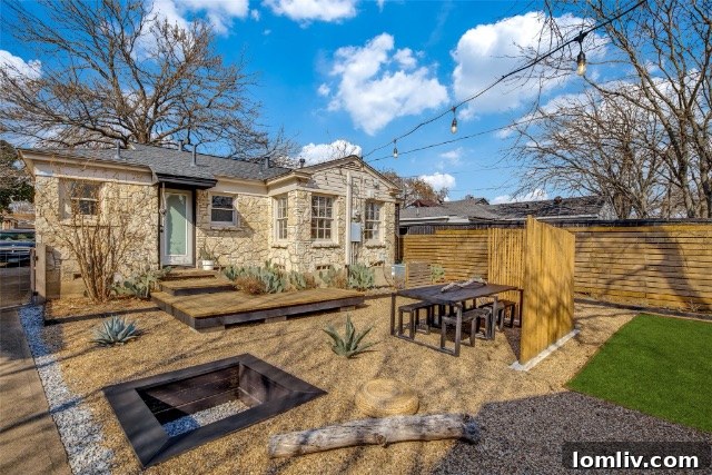 Outdoor seating area with gravel and lush green lawn beyond