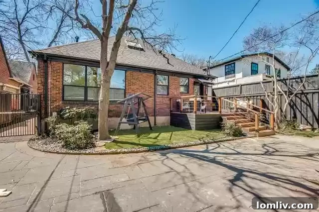 Beautifully landscaped backyard with a hardscaped patio and electric gate