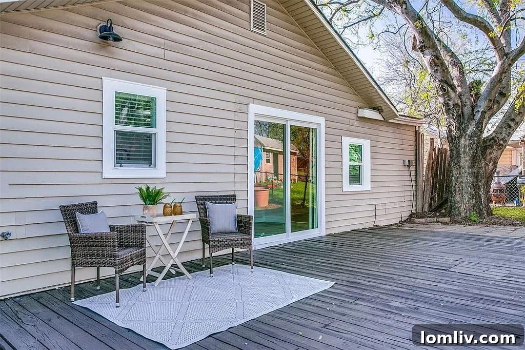 Spacious wooden deck leading to a large backyard with raised garden beds, mature trees, and ample green space in the Carrollton home.