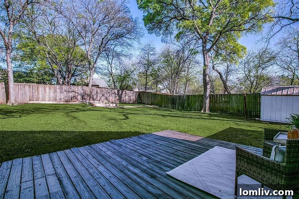 Panoramic view of the expansive backyard, showing green lawn, storage shed, and mature trees, highlighting room for recreation and a potential pool.