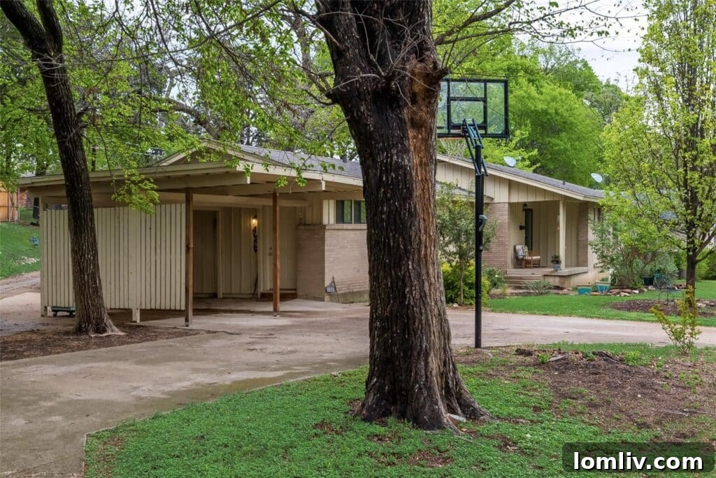 Welcoming exterior view of a charming midcentury artist's home in Club Oaks, Oak Cliff, featuring lush landscaping.