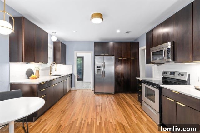 Spacious and bright kitchen featuring modern white subway tile backsplash, stainless steel appliances, and ample counter space with warm lighting