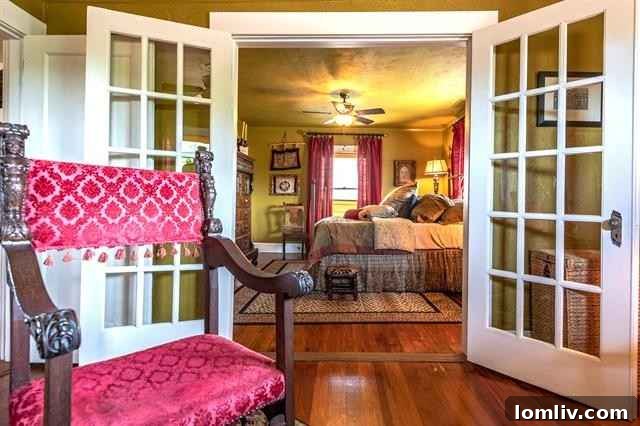 Spacious bedroom with French windows, warm mustard walls, and rich, layered decor in Fairmount residence