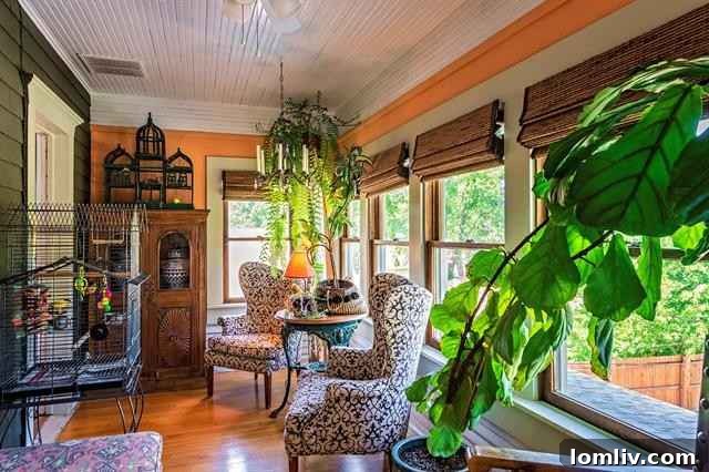 Sun-drenched enclosed sleeping porch transformed into a charming mini-conservatory with potted trees and bird cages
