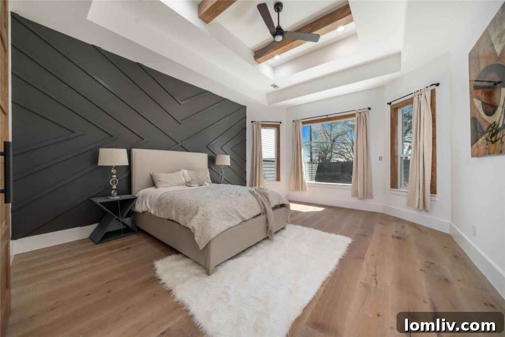 Luxurious primary bedroom with wide plank hardwood floors and unique ceiling design