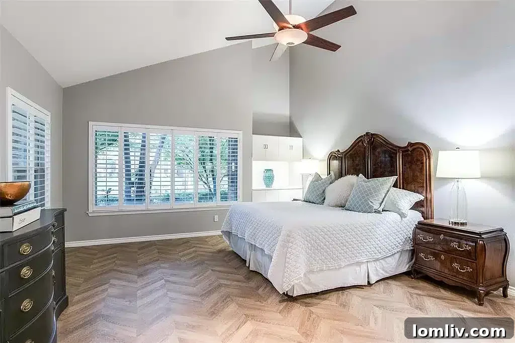 Luxurious primary bedroom with herringbone floors and vaulted ceilings