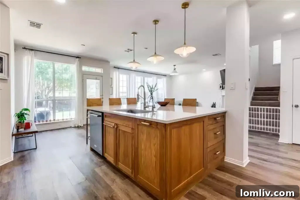 View of the modern kitchen island with ample seating and integrated storage in this renovated Plano home.