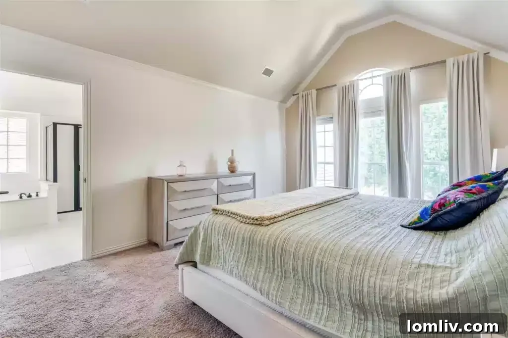 Luxurious primary bathroom featuring dual vanities, a freestanding soaking tub, and elegant black and gold accents.