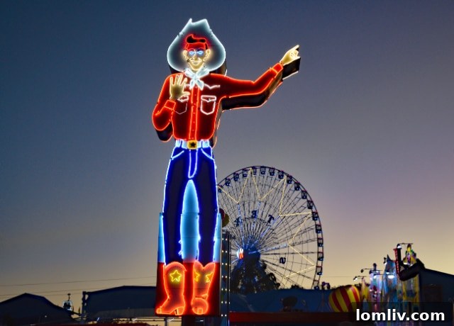 Neon Big Tex statue illuminated at dusk at the State Fair of Texas