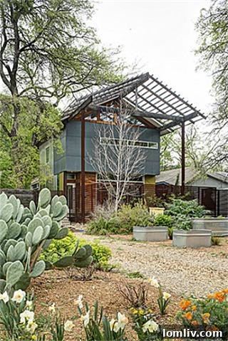 Rear view of the modern home at 8643 Groveland, showing multiple levels, balconies, and its integration with the landscape.