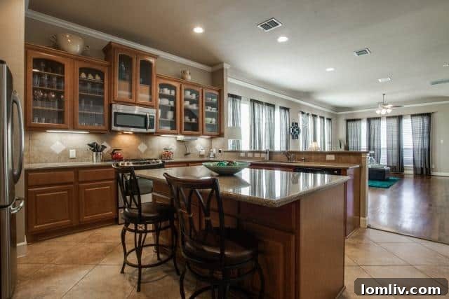 Modern kitchen with large island, stainless steel appliances, and granite countertops in a Dallas urban home
